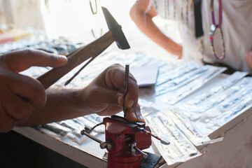 Close up of unrecognizable person holding a hammer and working with metal. Tunisia