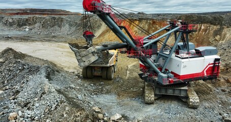 Excavator loading dump truck in open pit mine. Stock clip