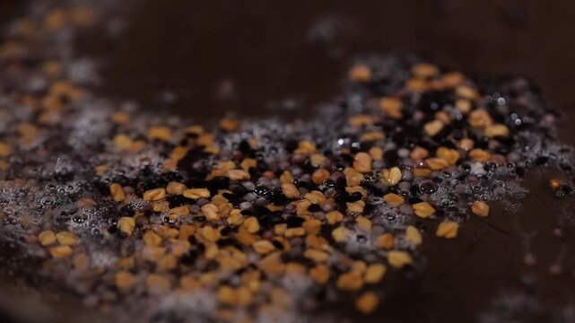 Adding spices in hot oil for cooking.