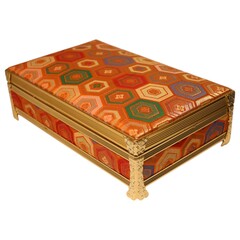 A fabric-covered jewelry box with decorative edges, a velvet-lined interior, and a built-in music box that plays when the lid is opened. II