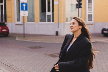 Fototapeta premium Details of everyday elegant black and blue look. Model wearing casual outfit. Grey dark jacket, blue top in trendy minimalistic style. Street fashion for spring or fall season. Woman go to work.