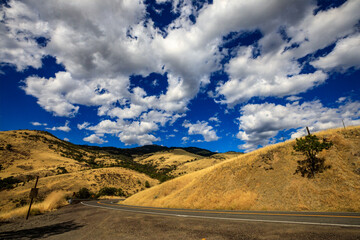 Serene Open Road with Sunlit Clouds and Mountain Range
