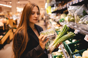 Business woman buy healthy food item. Girl take vegan herb. Adult lady shop eco market. Bio farm grocery store. Buyer girl put organic meal cart. Person keep raw diet. Client go local supermarket. 