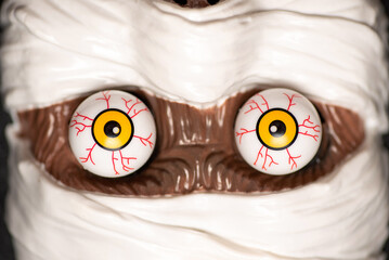 Close-up of a mummy's face with striking eyes and white bandages