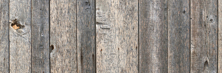 Rustic weathered wooden planks with knots and natural texture in vertical alignment.