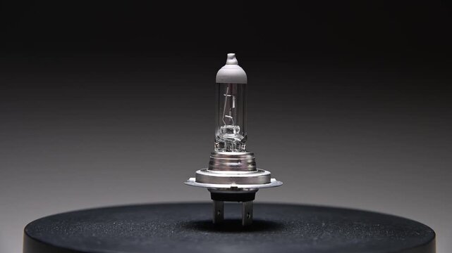 A new spare part rotates on a black gradient background. A car light bulb.