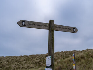 Close and selective focus on the wooden Norfolk Coast Path sign in Winterton sand dunes