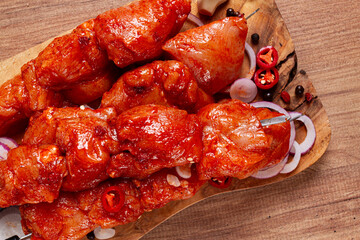 chicken fillet on skewers, marinated in spices, on a wooden chopping board, top view, no people,