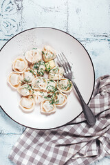 homemade dumplings, on a plate, with herbs on a rustic table