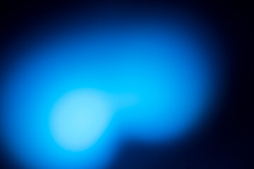Soft abstract blue glow with blurred light shapes on a dark gradient background