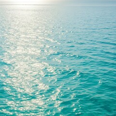 Sunlit turquoise water surface displays shimmering reflections, creating a tranquil and peaceful seascape.