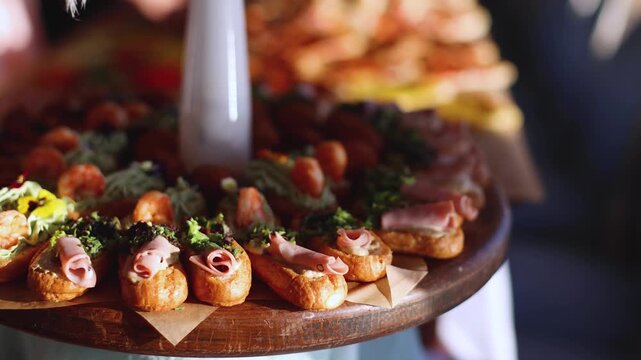 Beautifully decorated banquet catering table, with variety of with different food snacks appetizers on corporate birthday party event or wedding celebration, canape, salad, delicatessen setting