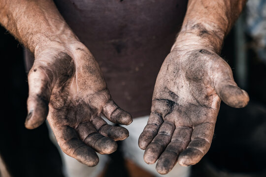 Close-up of dirty hands of caucasian adult male miner in workwear
