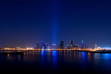 Fototapeta premium Blue hour photograph of a city skyline illuminated with blue lights — global awareness of World Diabetes Day