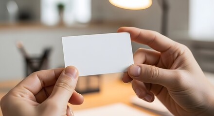 Obraz premium Person holding a blank white business card for contact information