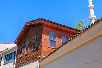 Traditional wooden house with blue sky and minaret in background