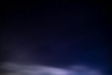 Naklejka premium Starry night sky with dark clouds and distant stars
