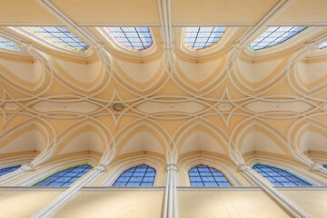 Intricate vaulted ceiling and stained glass windows in historic cathedral