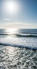 Obraz premium Sun-drenched ocean waves, showcasing a serene coastal scene with brilliant light reflecting on the water's surface.