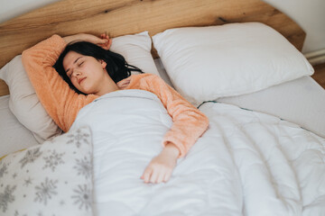 A serene scene of a woman comfortably asleep under a white blanket in bed