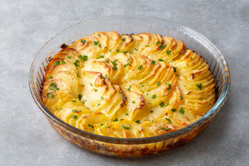 Potato gratin - graten (baked potatoes with cream and cheese) with rosemary and forks (Turkish name; Kremali patates)