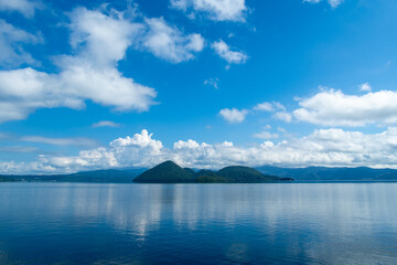 Lake Toya in summer, surrounded by blue skies and clouds