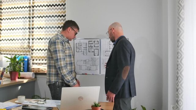 discussion about layout modifications and structural costs in detail, client and architect collaboratively review and analyze floorplan modifications and structural changes with detailed cost