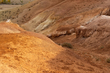 Red sandy mountains in Altai, reminiscent of Martian landscapes. The terrain has various shades of red and orange, with dry rocky surfaces.