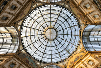 Obraz premium Milan, Italy - Sept. 11, 2025: With its distinctive glass dome and cast iron roof, the massive Galleria Vittorio Emanuele II off the historic Piazza del Duomo is home to Milan's most luxurious shops.