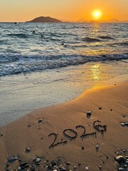 2026 new year concept. 2026 Written in Sand on a Beach with Golden Sunset Reflection