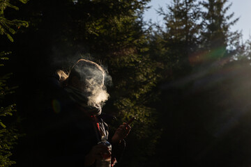 Fototapeta premium young woman smoking on a dark background