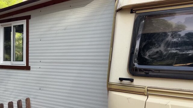 Paneo exterior de caravana con extensi&oacute;n y hombre mirando por la ventana 4K