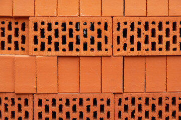 A stack or wall of red bricks with holes