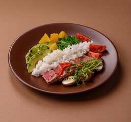 Seared tuna tataki in a bowl with sesame seeds, rice, and vegetables. Tuna tataki