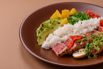 Seared tuna tataki in a bowl with sesame seeds, rice, and vegetables. Tuna tataki