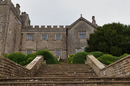 A stately stone building with crenellations sits atop a terraced hillside in Sizergh - Kendal - Lake District - UK