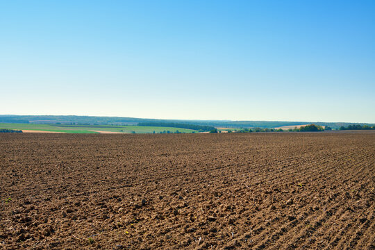 A plowed agricultural field against a blue sky