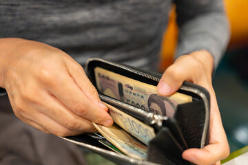 財布からお金を出す男性