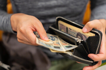 財布からお金を出す男性