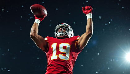 American football player celebrates touchdown with arms up. Man in red jersey with number 19 holds ball. Player wears red gloves, white helmet. Bright lights shine on stadium field at night.