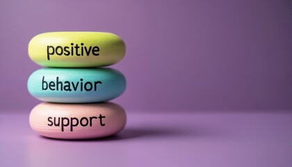 Colorful wooden blocks stacked. Positive behavior support words written on blocks. Purple background with copy space. Blocks are yellow, blue and pink. Words are positive, behavior, support.