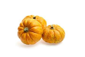 Three vibrant orange pumpkins with textured skin and green stems arranged artistically on a white background, showcasing seasonal harvest and autumnal themes
