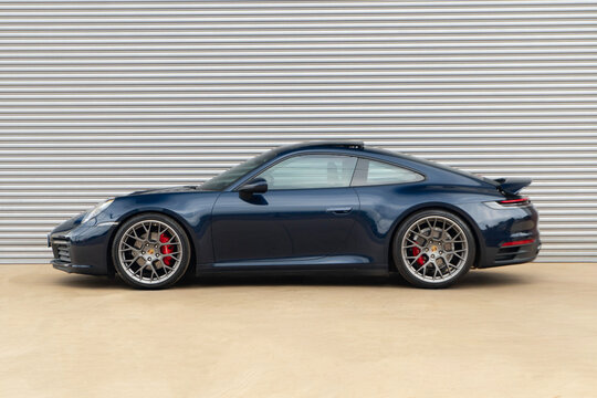 Dark blue Porsche 911 Carrera S side profile, luxury sportscar external view