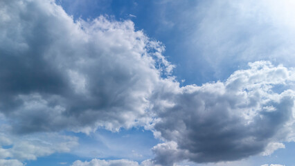A scenic view of fluffy clouds scattered in a bright blue sky creating a peaceful atmosphere. Perfect for nature, weather, and atmospheric concepts.