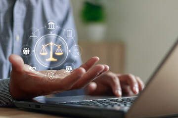 Businessman using laptop with virtual law and justice icon, symbolizing legal service, online consulting and business ethics in modern digital technology concept. Ideal for law firms and corporate use
