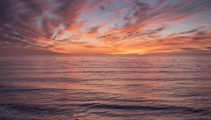 Fototapeta premium Morning sky with glowing cirrus clouds over calm ocean water at sunrise 