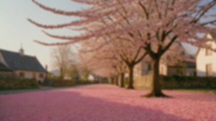 Obraz premium background blurred A cherry tree in peak bloom, pink petals on ground, small village behind, late afternoon, golden soft light, 70mm, slow pan right, Portra 400 sim, petals drifting.