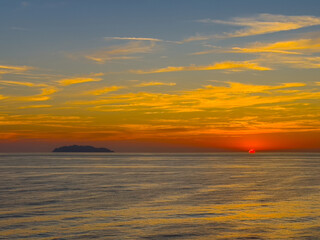 Livorno, Italy, Europe - July 14, 2024: Sunset over Ligurian sea outside the port. Island, Isola di Gorgona on horizon