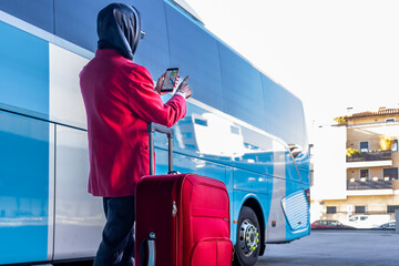 Latin businesswoman using navigation app near bus during trip