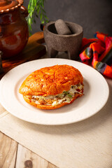 Pambazo. Mexican sandwich marinated in red sauce and roasted on a comal traditionally stuffed with potatoes and chorizo, a classic of Mexico City street food.